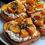 Spiced sweet potato and cottage cheese toast on whole grain bread, topped with maple drizzle and herbs, served on a rustic wooden plate